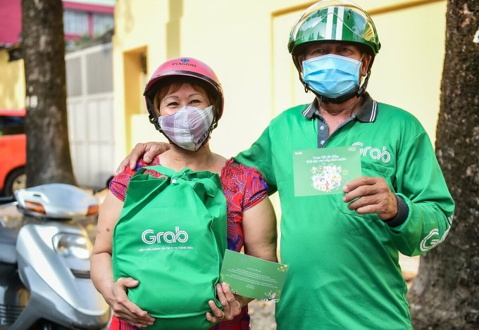 Một bác tài khác cũng cùng vợ đến nhận quà từ Grab, niềm vui thể hiện rõ qua ánh mắt của hai bác.