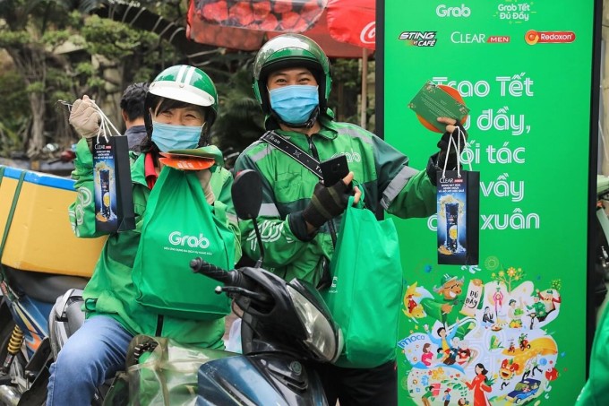 Chị Lê Thị Kim Hồng (bên trái, ngụ quận Bình Thạnh) nhận phần quà gồm gạo nếp, bánh kẹo và một số nhu yếu phẩm thiết yếu khác. Khi nhận tin nhắn từ Grab mời tham dự chương trình, tôi khá bất ngờ và cảm động vì trong năm qua công ty đã nhiều lần tặng quà nhân dịp 20/10, hỗ trợ phòng chống dịch..., chị Hồng chia sẻ.