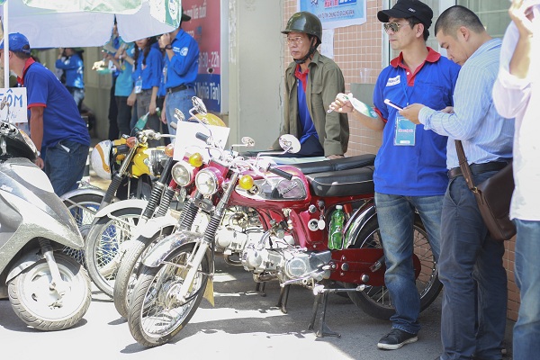Đội tình nguyện Honda67solo đứng trước cổng trường làm xe ôm miễn phí cho các sĩ tử.