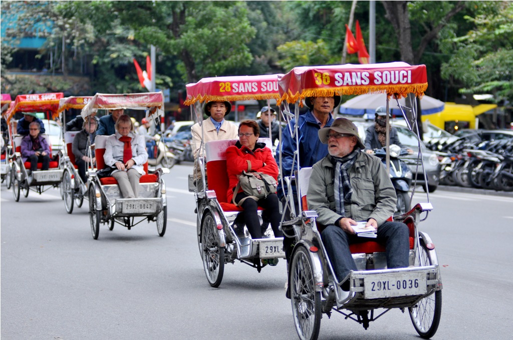 Trên phố, hàng chục chiếc xe xích lô đang đưa khách nước ngoài thăm quan phố phường trong tiết trời Hà Nội.