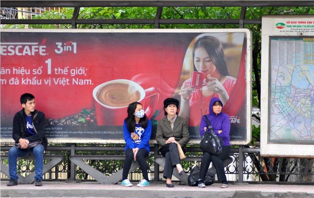 Người dân co ro ngồi tại điểm xe buýt trên đường Kim Mã đợi xe đến.