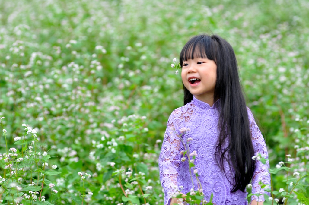 Nụ cười thích thú của một trẻ nhỏ được trải nghiệm trong rừng hoa.