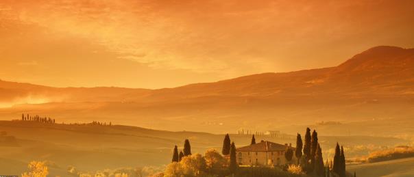 Những ngọn đồi buồn ngủ ở Tuscany sáng lên với màu cam khi mặt trời mọc lên từ phía đông vào một buổi sáng mùa thu trên đất Ý