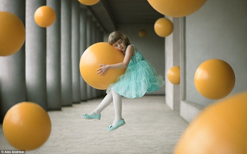 Bức ảnh đầy nghệ thuật về một bé gái ôm quả bóng lơ lửng trong không trung.