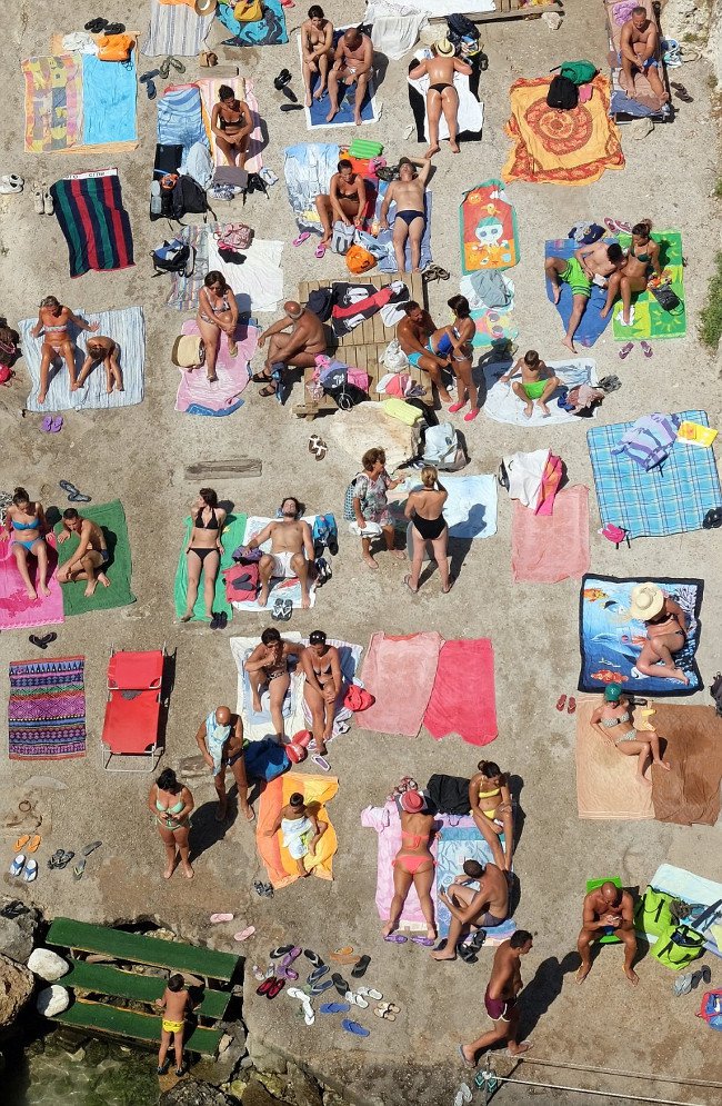 Du khách tắm nắng trên bãi biển ở Salento, Italy. 