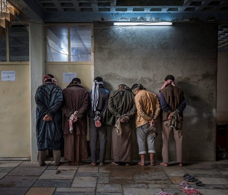 Những người đàn ông ở vùng Hawija, Iraq đang chờ người Kurd thẩm vấn tại một căn cứ gần Kirkuk. 