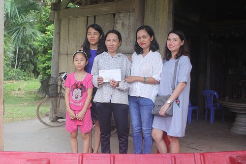 Chị Nguyễn Thị Hường và nhà tài trợ trước căn nhà của chị