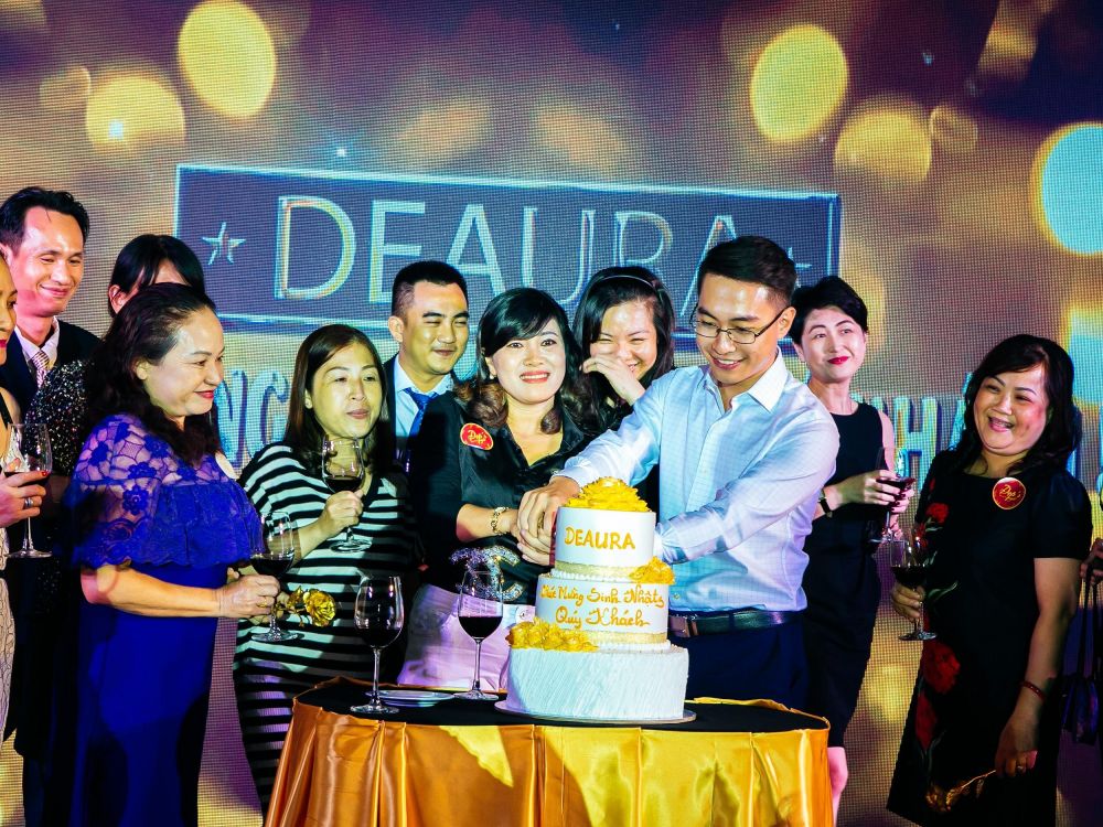 Các khách hàng và đại diện DeAura cùng nhau cắt bánh sinh nhật thiết kế riêng cho sự kiện