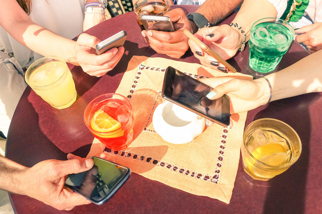 Thói quen dùng điện thoại khi ăn uống rất phổ biến hiện nay.