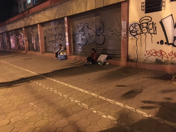 Người vô gia cư thu mình chống chọi với cái lạnh bên vệ đường Hai Bà Trưng.