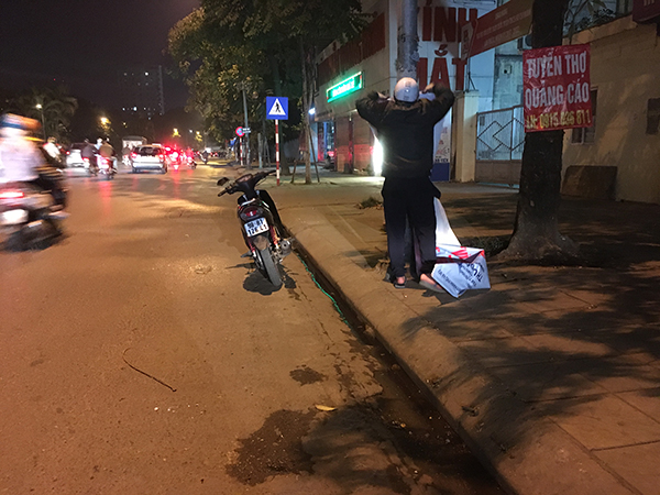 Người đàn ông một mình đi thu lại những băng rôn khẩu hiệu hết thời gian sử dụng trên đường Nguyễn Chí Thanh.