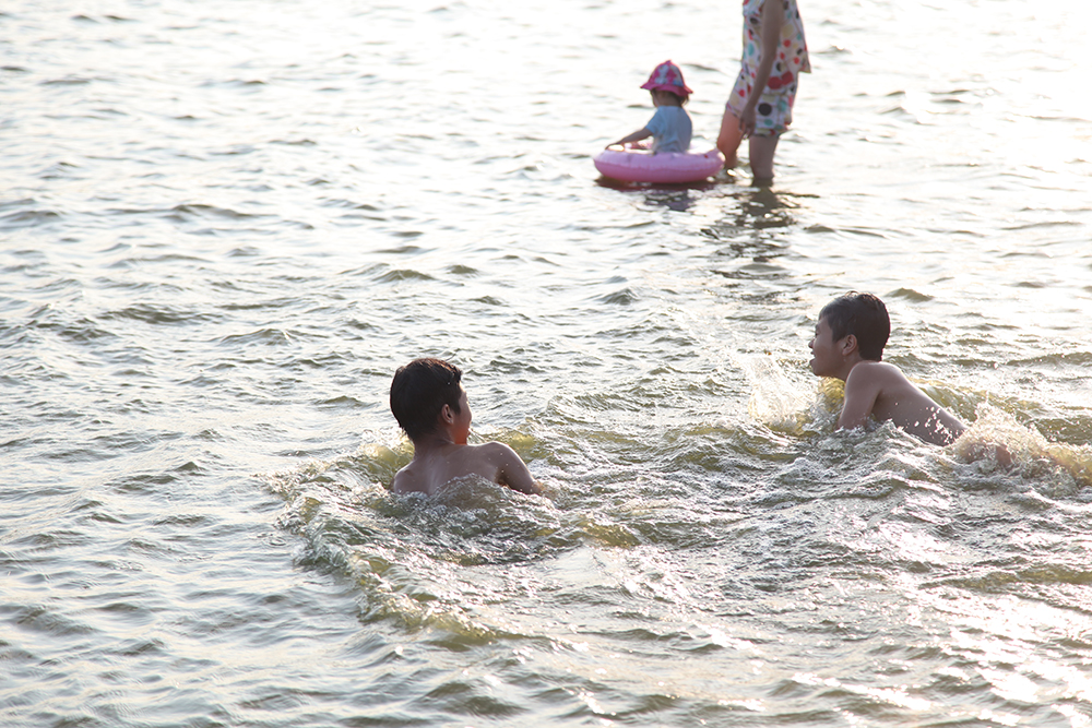 Các bạn trẻ tươi cười vui đùa với làn nước của Hồ Tây.