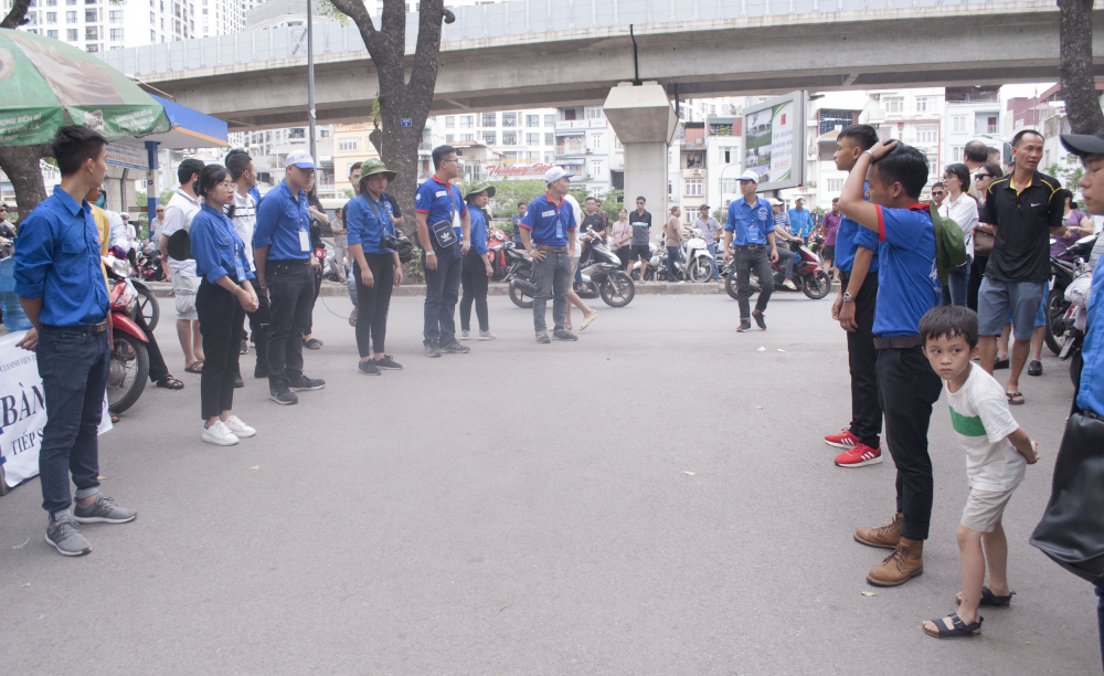 Sinh viên tình nguyện đứng thành lối hướng dẫn các thí sinh di chuyển giảm thiểu ách tắc giao thông