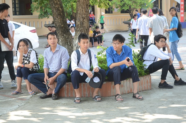 Ngày làm thủ tục, thời tiết Hà Nội khá oi bức nên nhiều học sinh và phụ huynh trong lúc chờ đợi đã cố tìm những bóng cây để tránh nắng. Ảnh Ngô Chuyên.