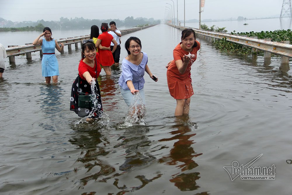 Nhiều người vui vẻ chụp ảnh trên tuyến đường ngập lụt 