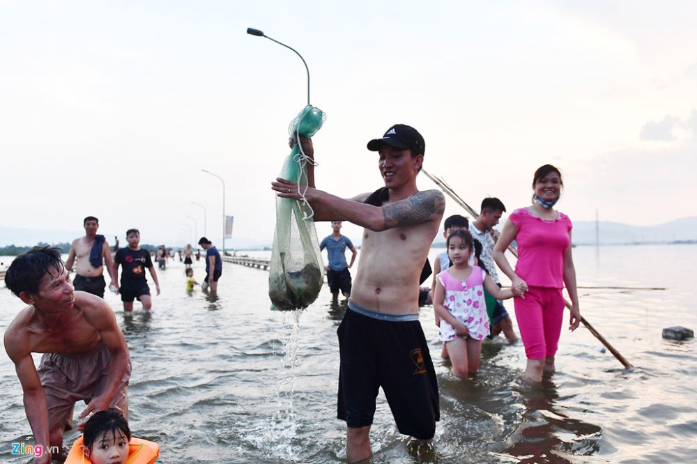 Một thanh niên sống ở thị trấn Quốc Oai mang lưới ra bắt cá. (Ảnh: Zing.vn)