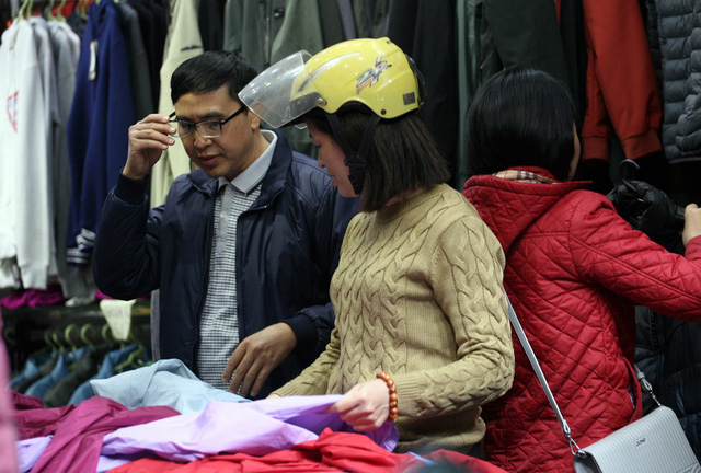 Đôi vợ chồng tranh thủ lúc đi làm về tạt mua những chiếc áo khoác với giá giảm lên đến 50%.