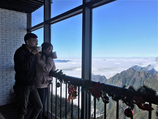 Trên khu vực đỉnh, nhiều du khách thích thú thưởng thức ly trà táo quế ấm nồng và cùng nhau ngắm khung cảnh lãng mạn hiếm có.