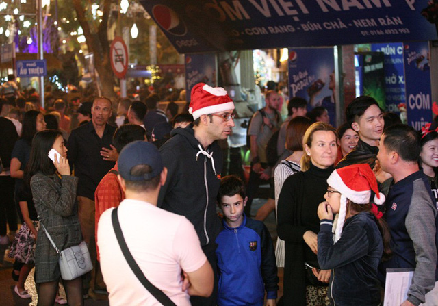 Nhiều du khách ngoại quốc cũng hòa mình vào dòng người chào đón Giáng sinh.