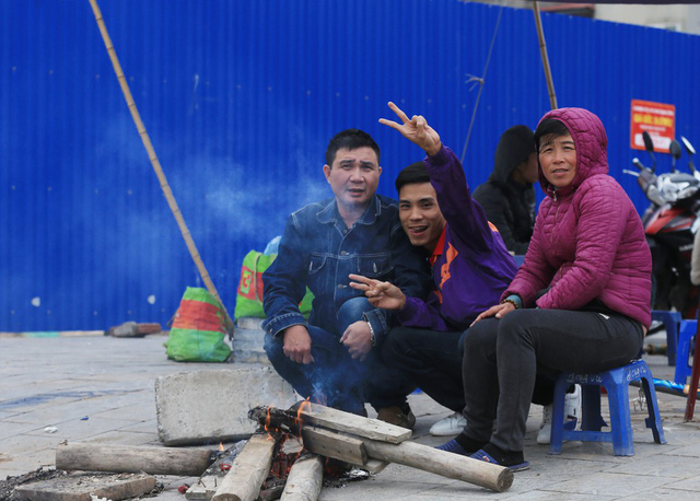 Trên đường Phạm Văn Đồng, nhiều người dân tranh thủ sưởi ấm cơ thể trước khi bắt đầu công việc mới của mình.