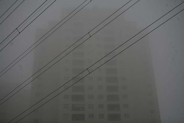 Cận cảnh một tòa nhà cao 30 tầng bị sương mù bao phủ.