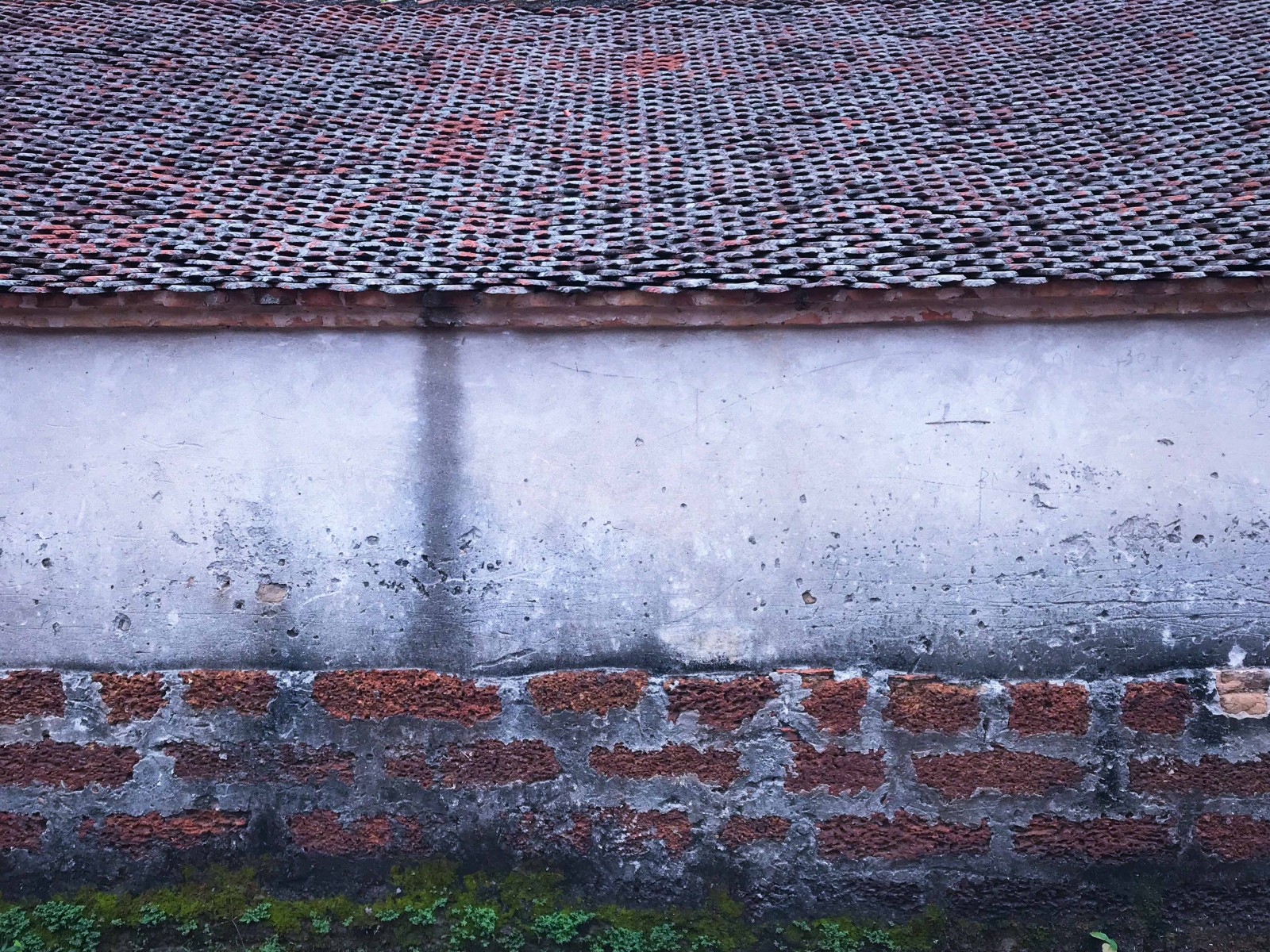 Nhà có mái nhà lợp ngói mũi, tường xây bằng đá ong.