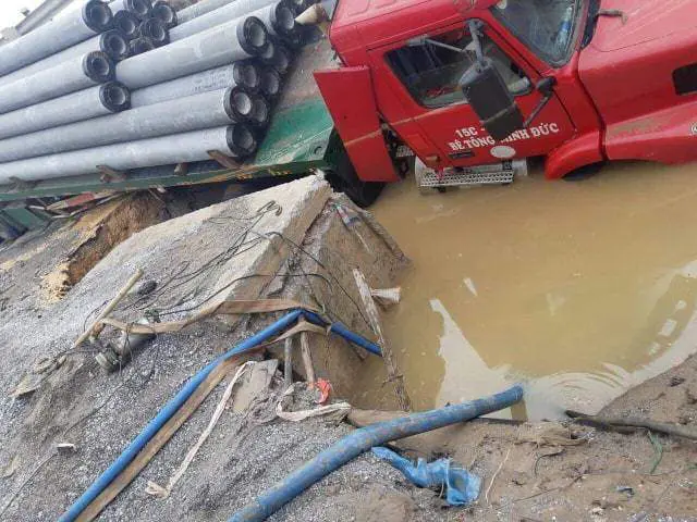 Chiếc xe container trọng tải lớn đè vào hố van xả cặn, làm vỡ đường ống nước sạch sông Đuống, Hà Nội.