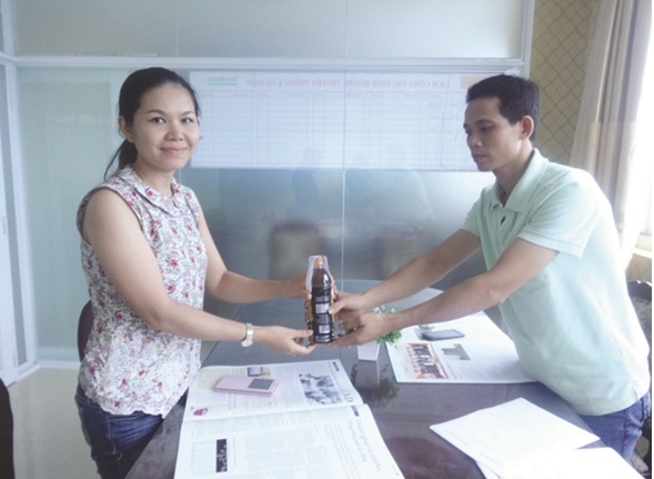 Bà Nguyễn Thị Thanh Thảo, đại diện Công ty URC tiếp nhận sản phẩm Trà xanh C2 Ô Long chanh bị lỗi từ anh Phan Quốc Phúc.