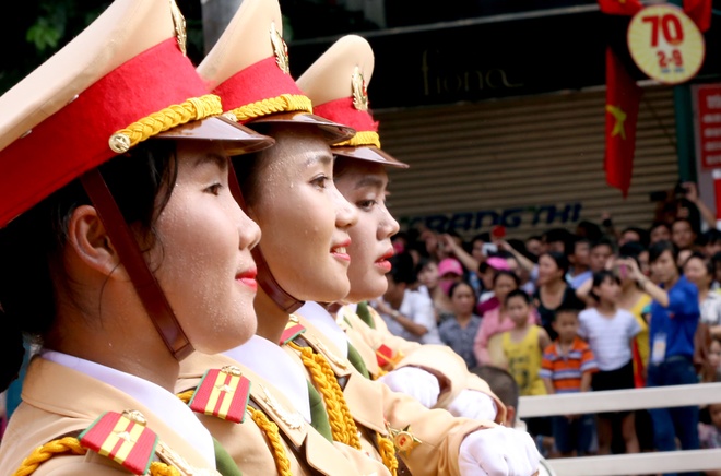Các nữ chiến sĩ cảnh sát giao thông dù mướt mồ hôi vẫn tươi cười chào nhân dân khi đi qua phố Tràng Thi.