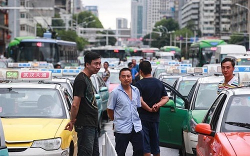 Tài xế taxi bỏ xe xếp hàng dài gây tắc nghẽn giao thông ở thành phố Vũ Hán (Trung Quốc)
để “bỏ phiếu bày tỏ sự bất mãn” đối với Uber vào ngày 10/08/2015. Ảnh: Telegraph.