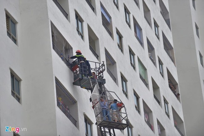 Xe thang vươn lên tầng 9 và cảnh sát cắt lưới kim loại để giải cứu người dân trong vụ hỏa hoạn ngày 16/9 tại chung cư HH4A Linh Đàm. Ảnh: Hoàng Anh.