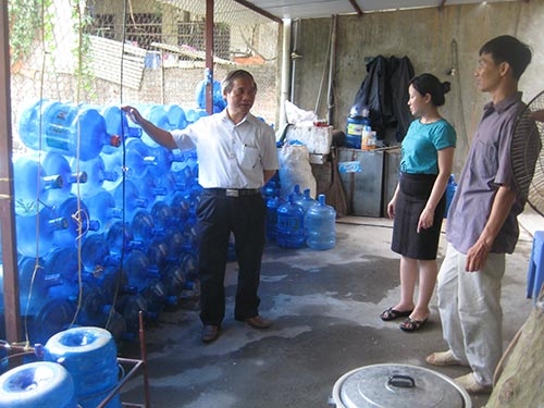 Lực lượng chức năng kiểm tra cơ sở sản xuất nước đóng chai. Ảnh: Giao thông