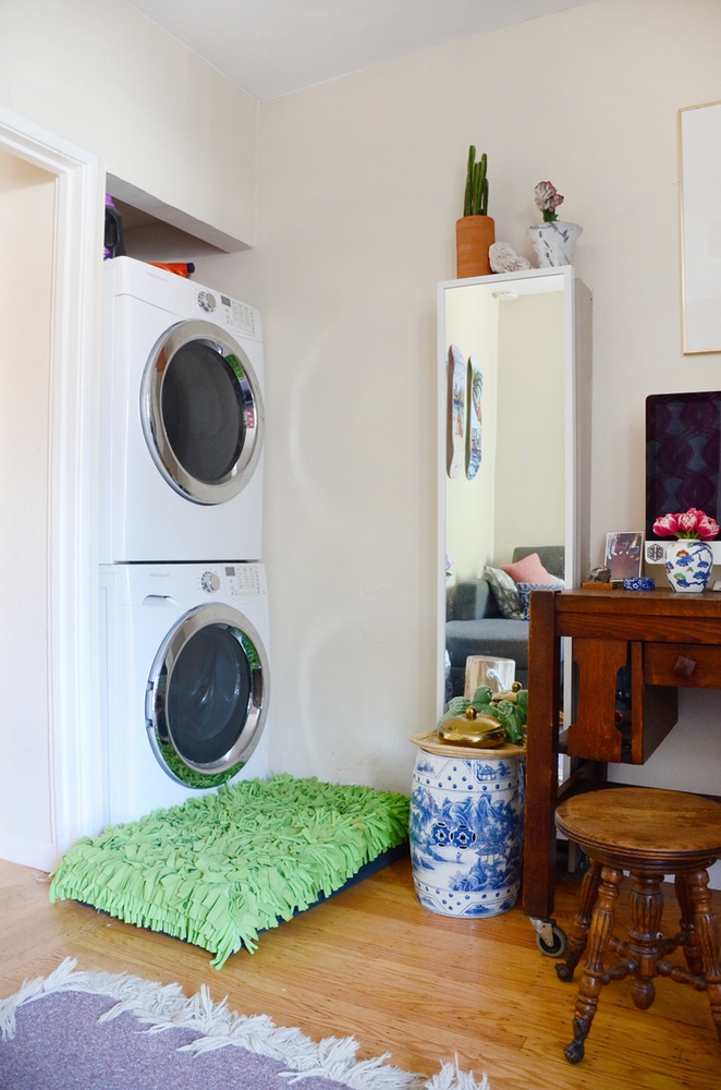 Vì căn hộ có diện tích nhỏ nên máy giặt và máy sấy được đặt ngay trong phòng khách.