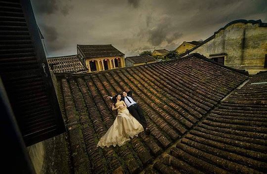 Hai bạn trẻ nằm trên mái ngói của một ngôi nhà cổ ở Hội An để chụp ảnh cưới. (Ảnh: F.B) 