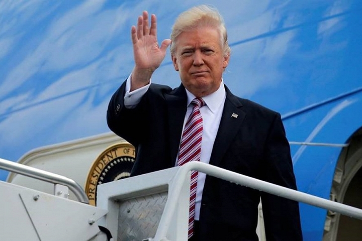 Tổng thống Donald Trump vẫy tay ở cửa chuyên cơ Air Force One. Ảnh: AP.
