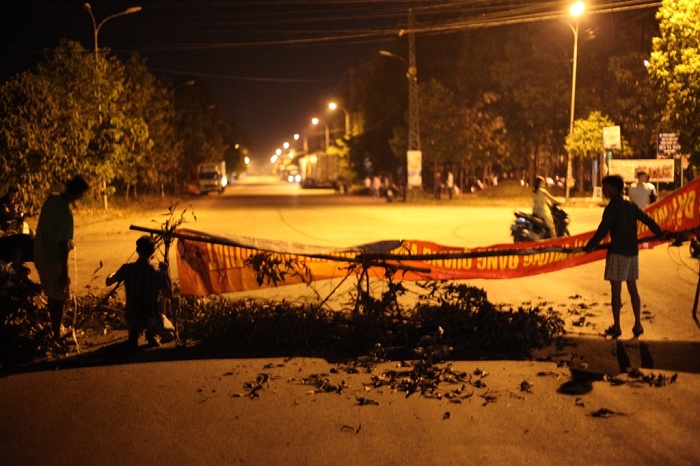 Người dân đã dùng cành cây, băng rôn chắn gần hết lòng đường khiến các xe tải chở hàng không thể ra và vào Khu công nghiệp Quảng Phú. 