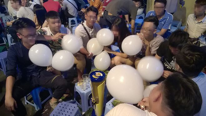 Một nhóm bạn trẻ cùng sử dụng bóng cười tại khu phố Tạ Hiện, Hà Nội. Ảnh: T.P