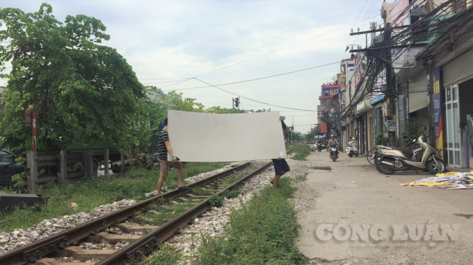 Người dân thản nhiên bê vác vật tư qua đường tàu bất chấp nguy hiểm