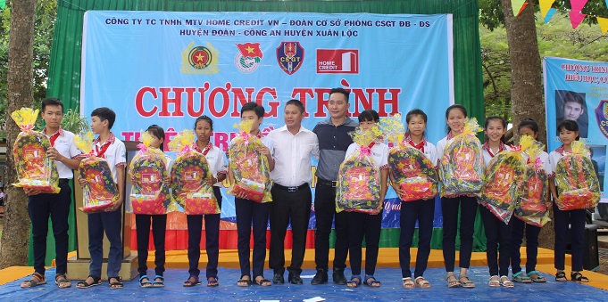 Ông Nguyễn Đức Thọ - đại diện Home Credit Việt Nam - trao quà cho các học sinh nghèo hiếu học của trường THCS Nguyễn Thái Bình và THCS Lý Thường Kiệt (Đồng Nai).