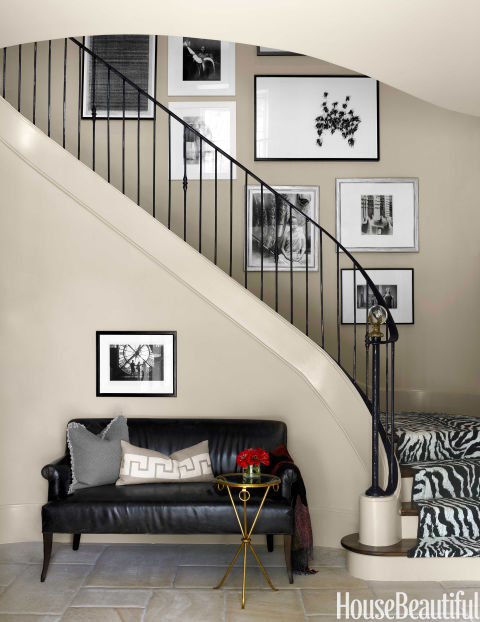 Lối lên cầu thang được treo những bức tranh đen trắng hút mắt, dưới cầu thang là chiếc ghế sofa nhỏ để bạn có thể ngồi đọc sách.