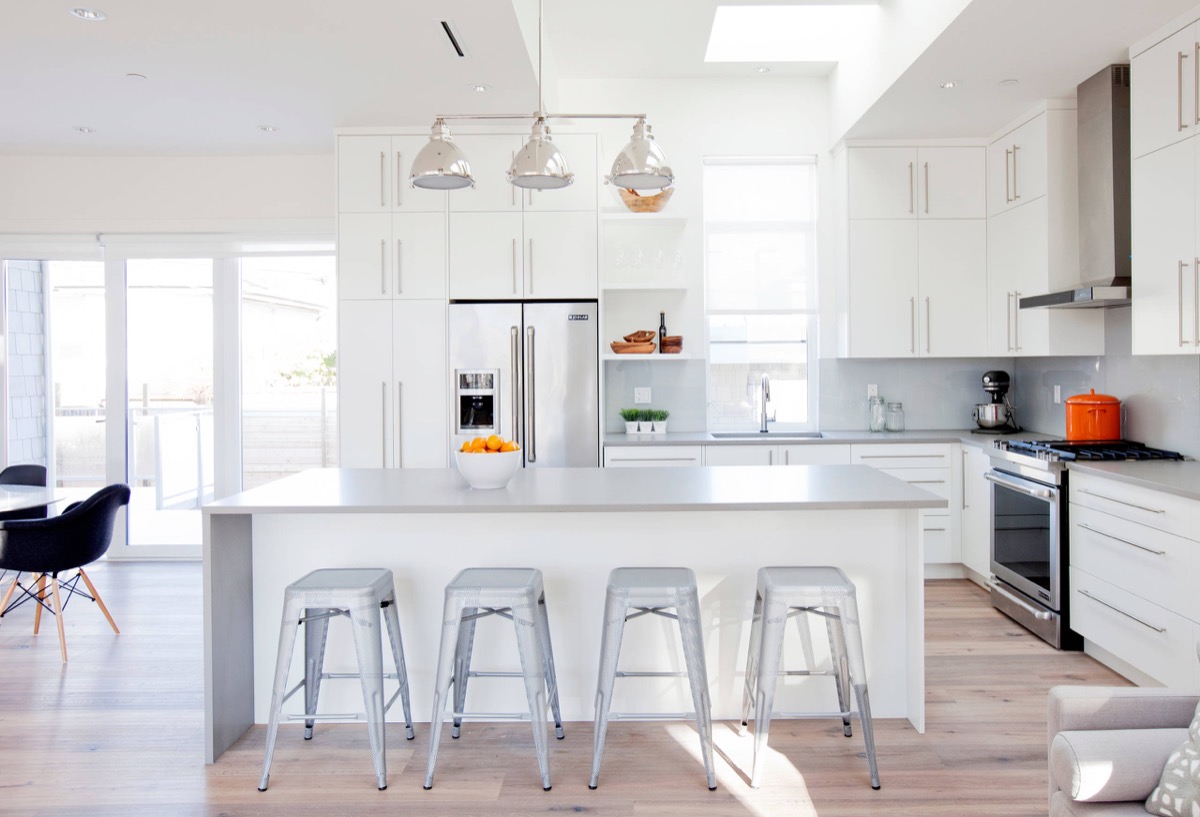 Nhà bếp tuyệt đẹp màu trắng và xám này có tủ trắng, bàn đá granit màu xám, phối hợp với các mặt phẳng ánh kim cũng khiến không gian nhà bếp rộng hơn.