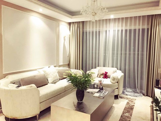 Phòng khách được thiết kế sát ban công với bộ sofa màu trắng sữa dịu nhẹ rất hợp tông với sơn tường và rèm.