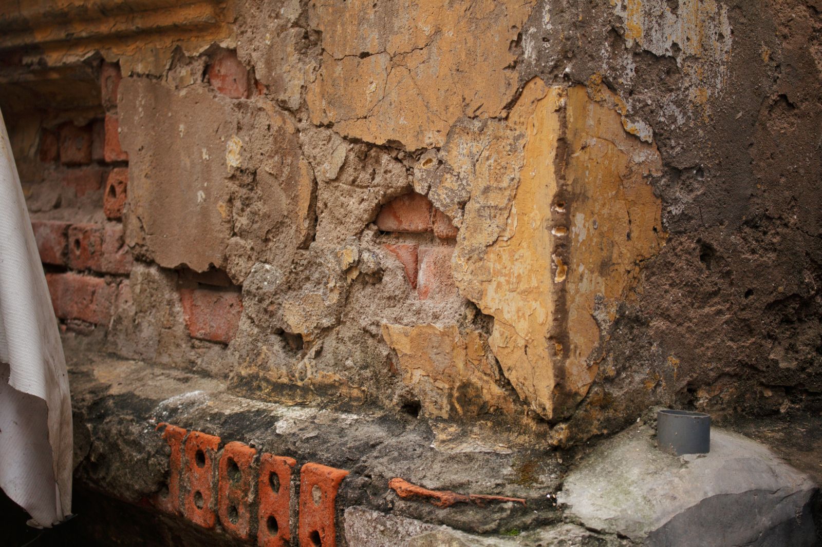 Những mảng tường bị vỡ để trơ ra gạch mà chưa được vá lại.