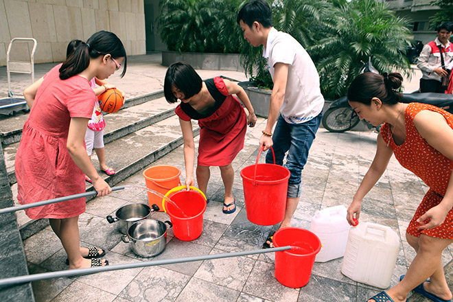 Người dân sống tại KĐT Tây Nam Linh Đàm mang xô, chậu, nồi, xoog, can nhựa… xuống sảnh lấy nước từ bề ngầm của tòa nhà về dùng (Nguồn: Dân Việt)