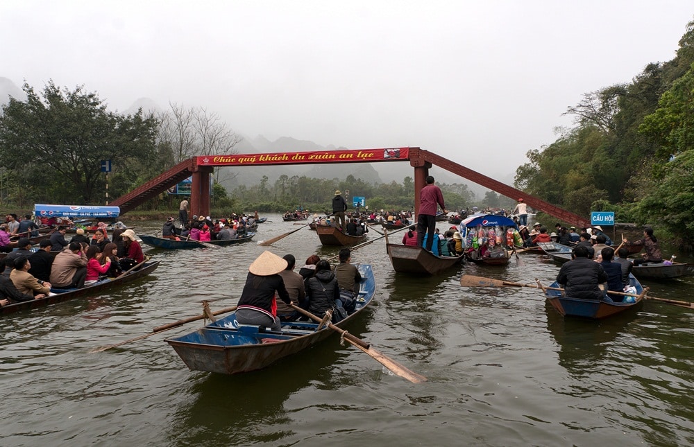 Du khách ngồi thuyền theo suối Yến vãn cảnh chùa Hương (Ảnh: Shutterstock)
