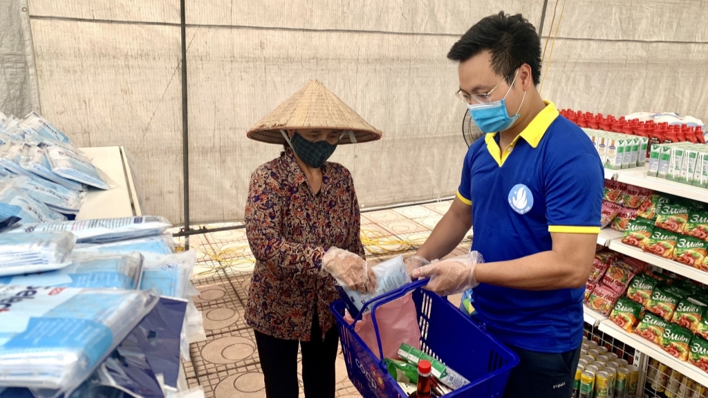 Đồng chí Trần Quang Hưng, Phó Bí thư Thành đoàn, Chủ tịch Hội Sinh viên thành phố Hà Nội hỗ trợ người dân mua sắm tại Siêu thị mini 0 đồng