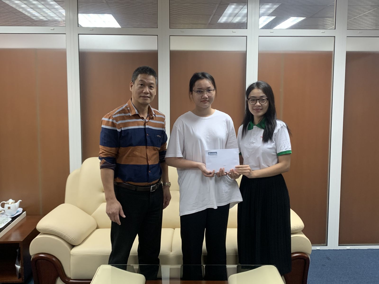 Ông Nguyễn Đình Hiếu và đại diện FE CREDIT trao học bổng cho em Ngô Thị Kim Cương