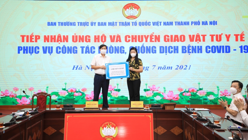 Chủ tịch Ủy ban Mặt trận Tổ quốc Việt Nam thành phố Hà Nội Nguyễn Lan Hương chuyển giao vật tư y tế phục vụ công tác phòng, chống dịch tới đại diện Sở Y tế Hà Nội.