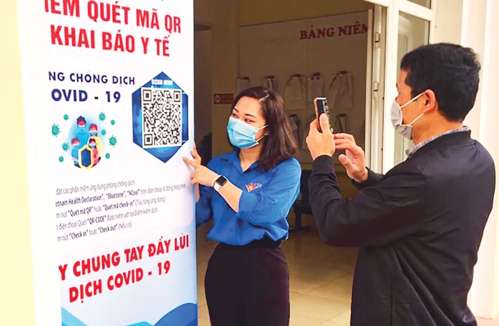 Đoàn viên thanh niên phường Quảng An (quận Tây Hồ) hướng dẫn người dân quét mã QR Code khai báo y tế để phòng, chống dịch Covid-19