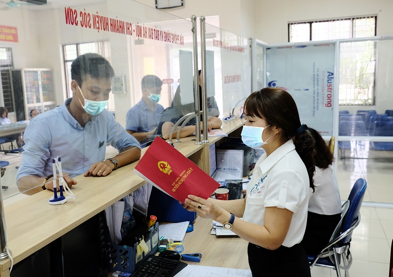 Giải quyết thủ tục hành chính cho người dân tại UBND huyện Sóc Sơn. Ảnh: Phạm Hùng